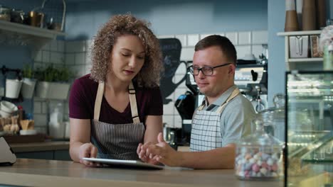 caucasian man with down syndrome learning how to take orders on digital tablet.