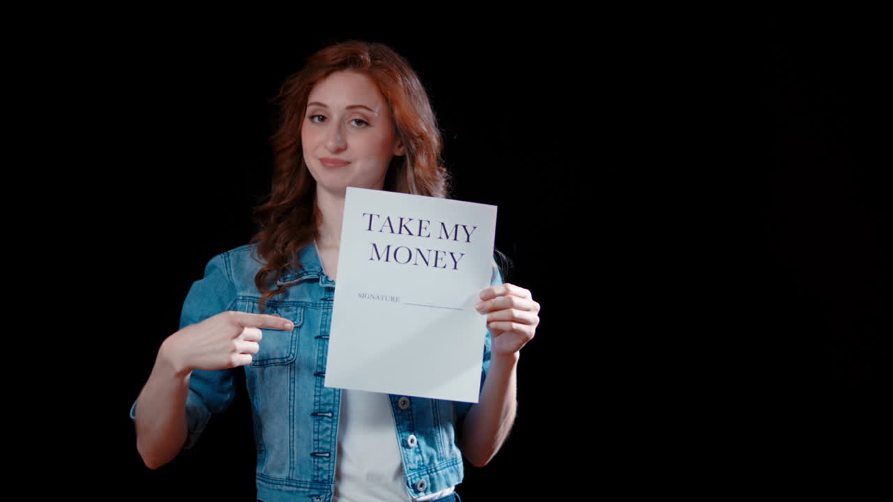 A young caucasian woman points to a paper saying &amp;quot;Take my money