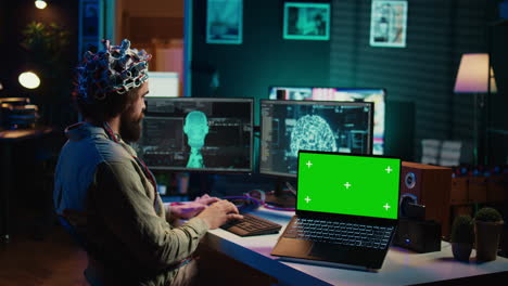 IT-Administrator-Codierung-Und-Verwendung-Des-EEG-Headsets-Zum-Hochladen-Des-Gehirns-Auf-Einen-Green-Screen-Laptop