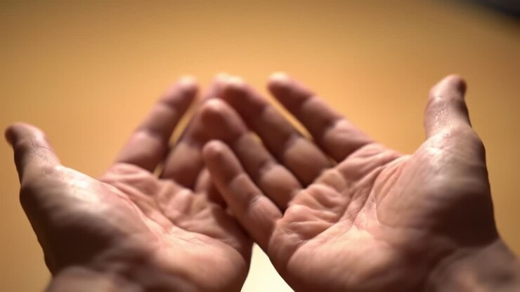 Two hands are open and facing upward, conveying a sense of invitation and trust. The soft lighting creates a warm atmosphere, suggesting a moment of sharing or contemplation.
