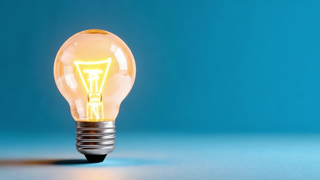 A Transformation of Light: From Unlit Glass to Illuminated Radiance Showcasing the Beauty of a Light Bulb Against a Captivating Blue Background