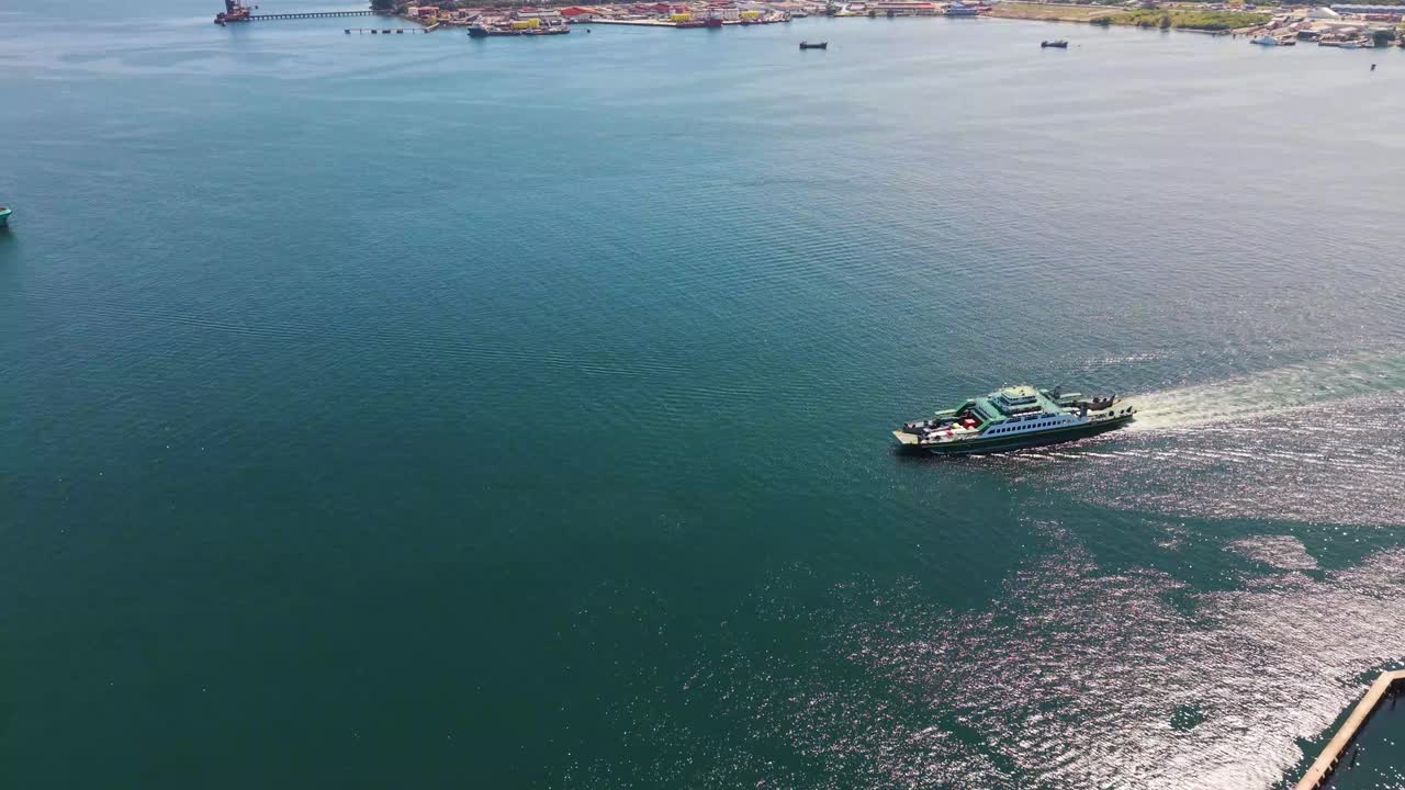 Aerial view of a Ro-Ro ship approaching Labuan Island port, Malaysia. Captured by drone showing the sea, coastline, and harbor activities in UHD clarity