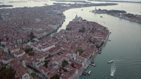 aerial revealing shot flying towards san marco over canal grande at dusk, venice, italy