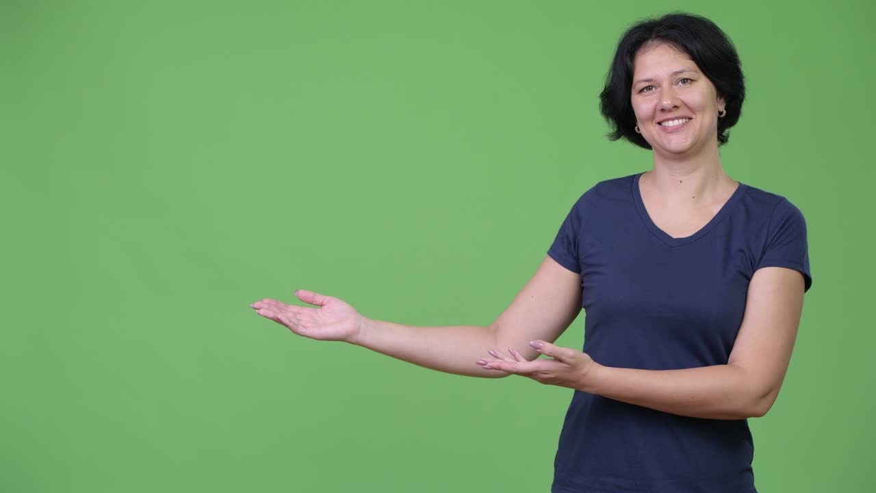 Bella donna con i capelli corti che mostra qualcosa
