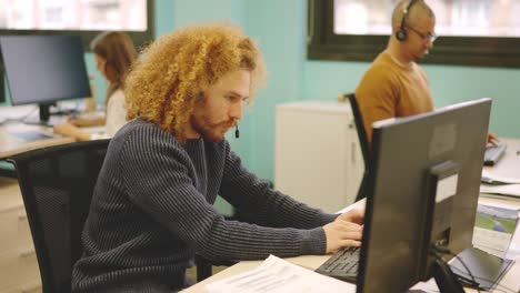modern man working in a coworking using computer and headset