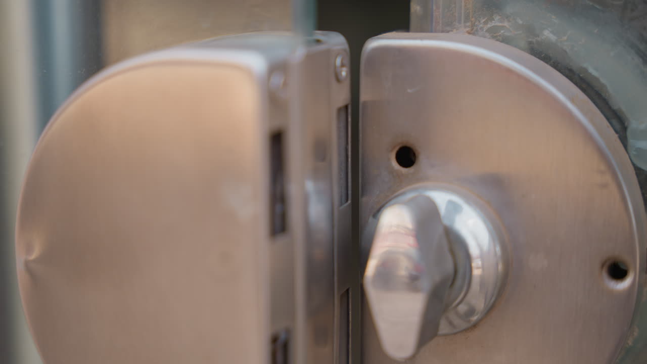 Dirty door lock closeup showing grime, worn metal thumb, black residue around thumbturn, residential entry, homeowner inspection, cleaning chore, muted natural light, textured close detail, practical
