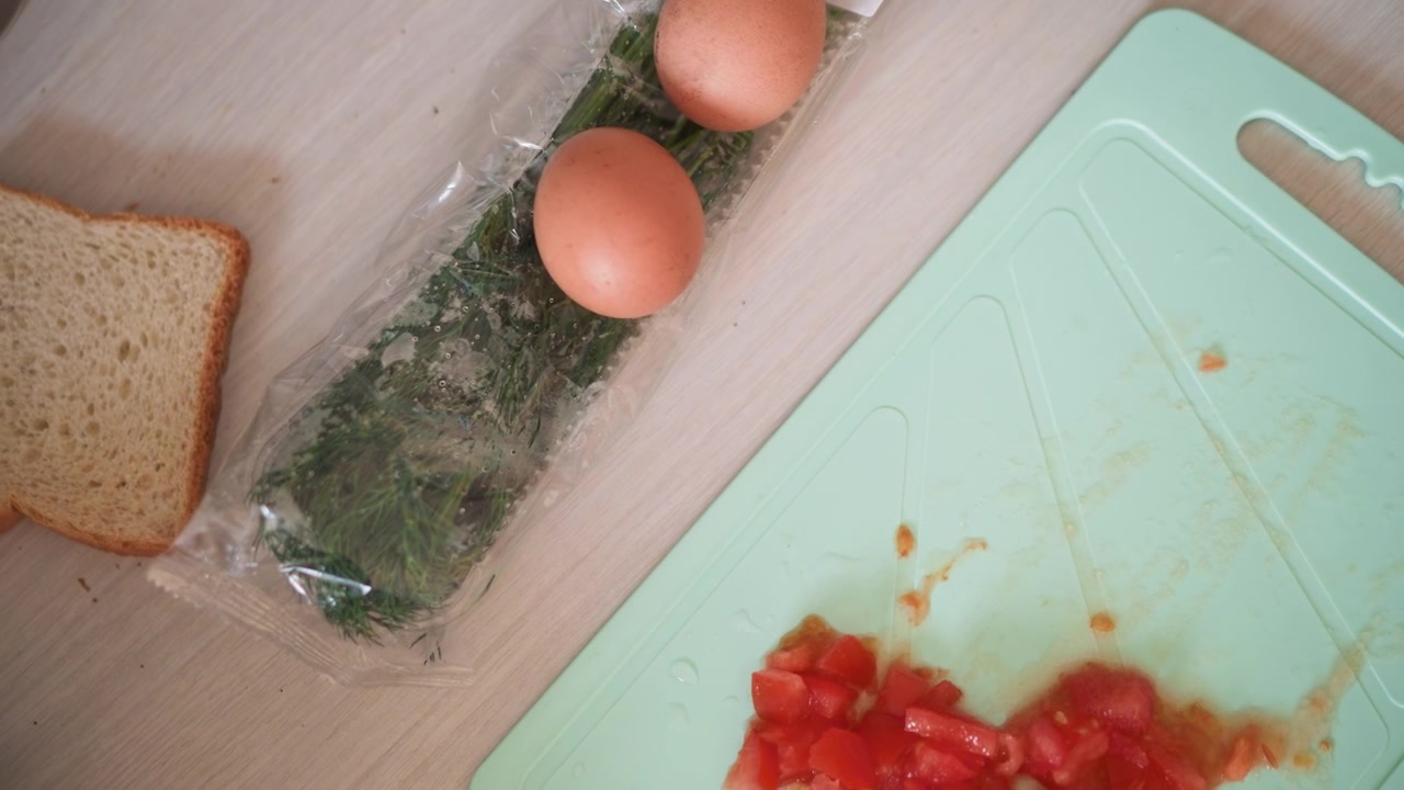 Studente che prepara rapidamente la colazione. Scena accogliente di preparazione di ingredienti freschi per la colazione alla luce del sole. Scena illuminata dal sole di uno studente che prepara un pasto mattutino veloce e fresco con uova e pane.