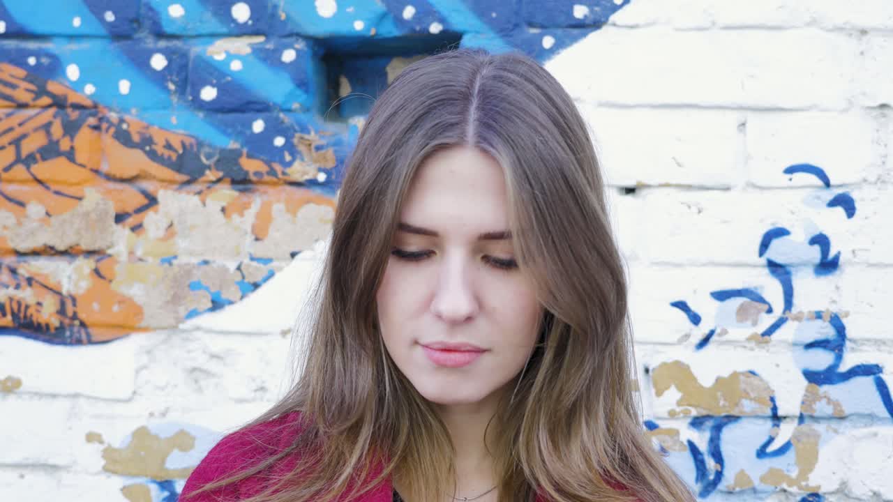 retrato de una mujer contra una pared de graffiti