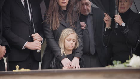 loss, grief and people at funeral with umbrella