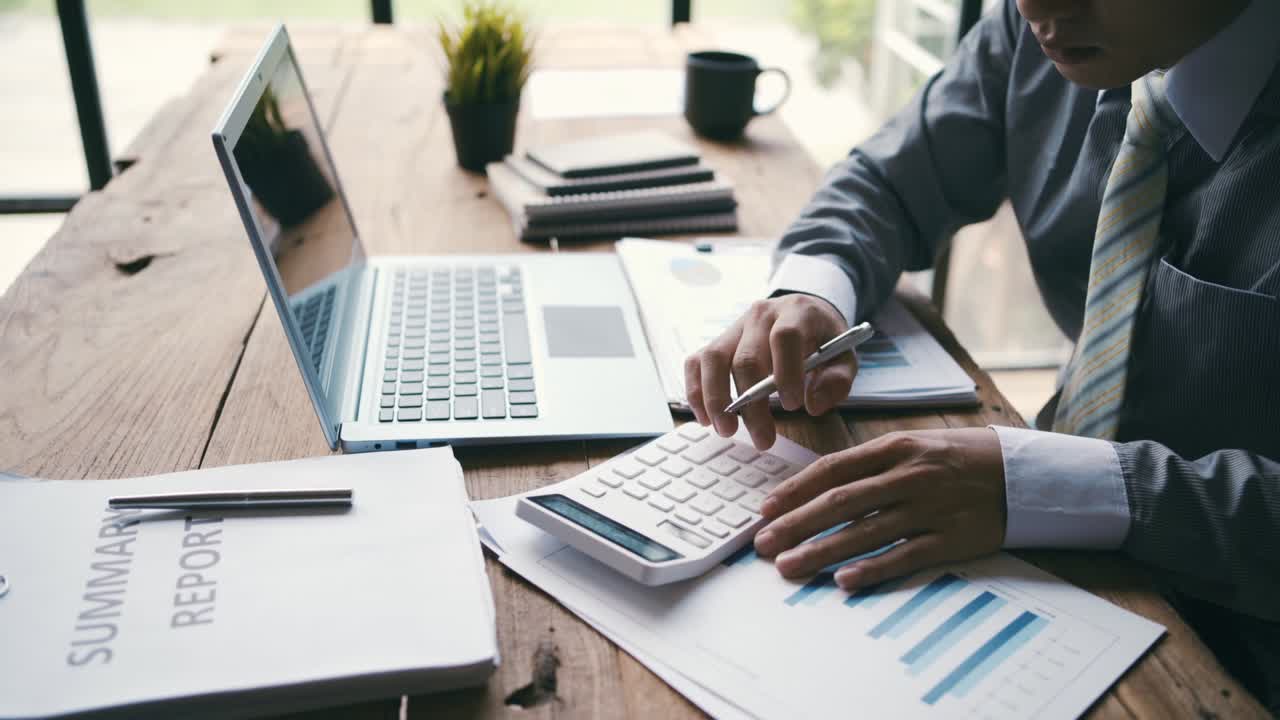 Businessman working on Desk office with marketing graph statistics analysis, Financial and tax systems concept.