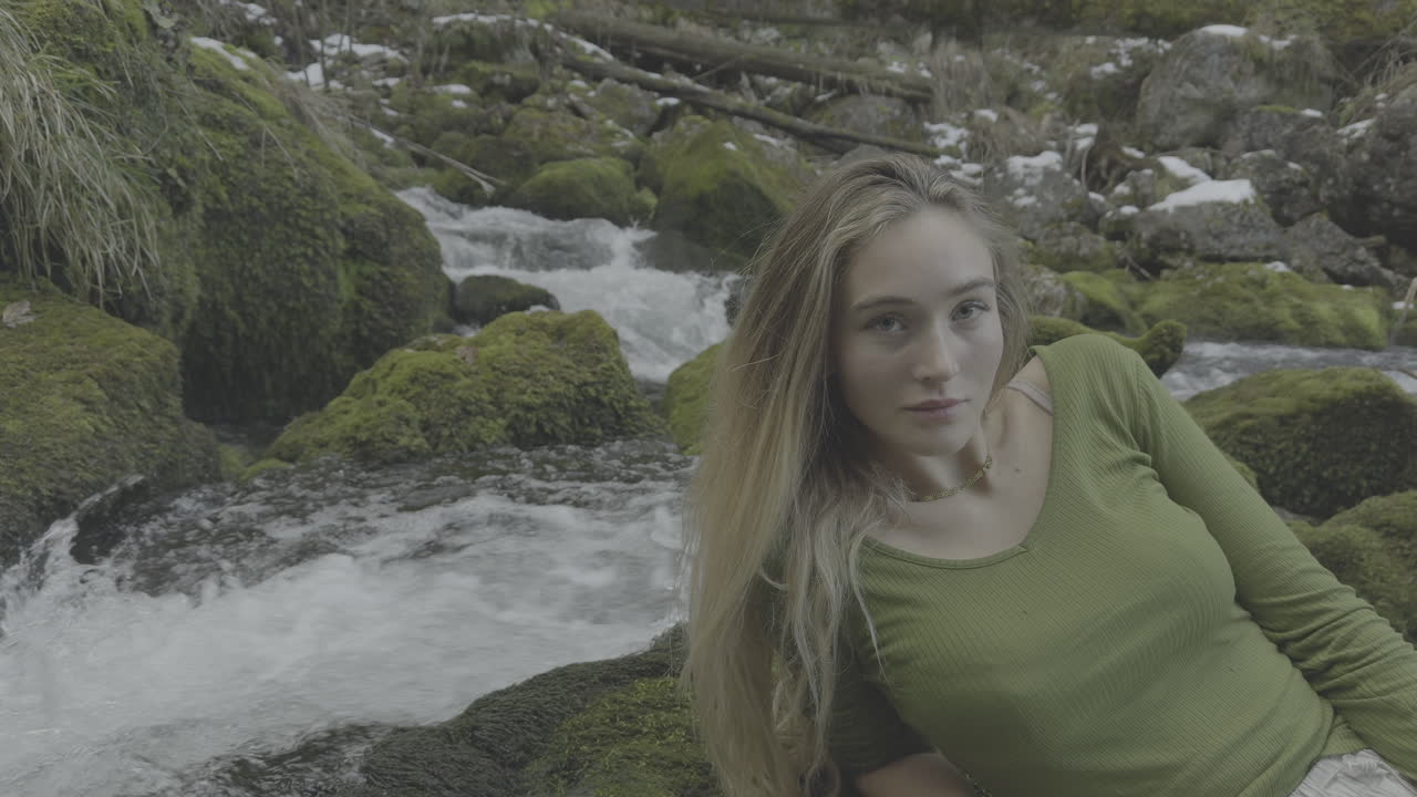 Young Woman Relaxing by a Mountain Stream