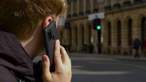 Over-the-Shoulder-Shot-of-Man-Talking-On-Mobile-Teléfono-On-Busy-Street