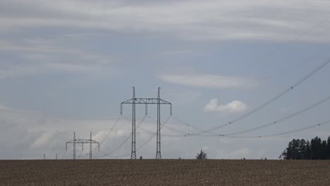 large view on the powerlines on the field. high voltage post or high voltage tower in field.