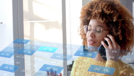 data processing on interface over biracial casual businesswoman talking on smartphone at office