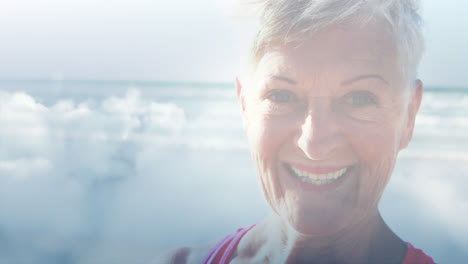 animation of glowing light over portrait of happy senior woman