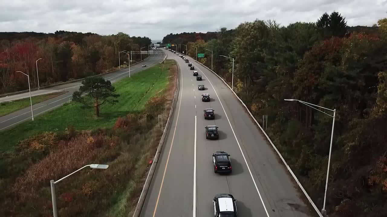 el cortejo fúnebre de la policía conduce bajo un dron
