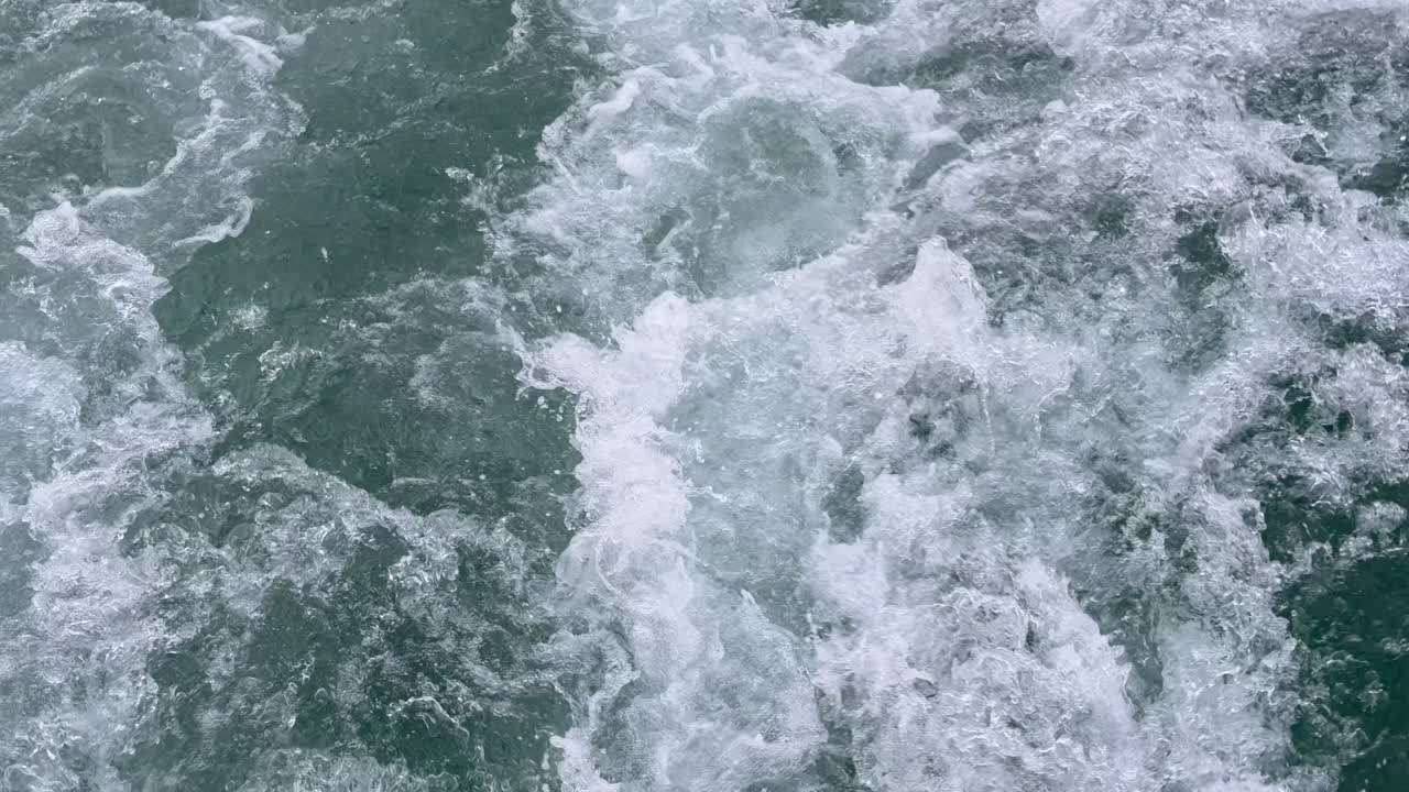 Vue hypnotisante de dessus au ralenti de puissantes vagues océaniques qui s'écrasent et se déchaînent. Belle mousse de mer blanche dynamique et éclaboussures d'eau créant un fond abstrait de nature marine.