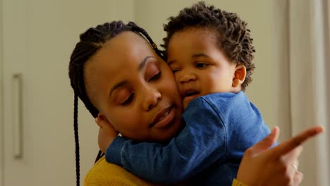 front view of cute little black baby boy embracing his mother in a comfortable home 4k