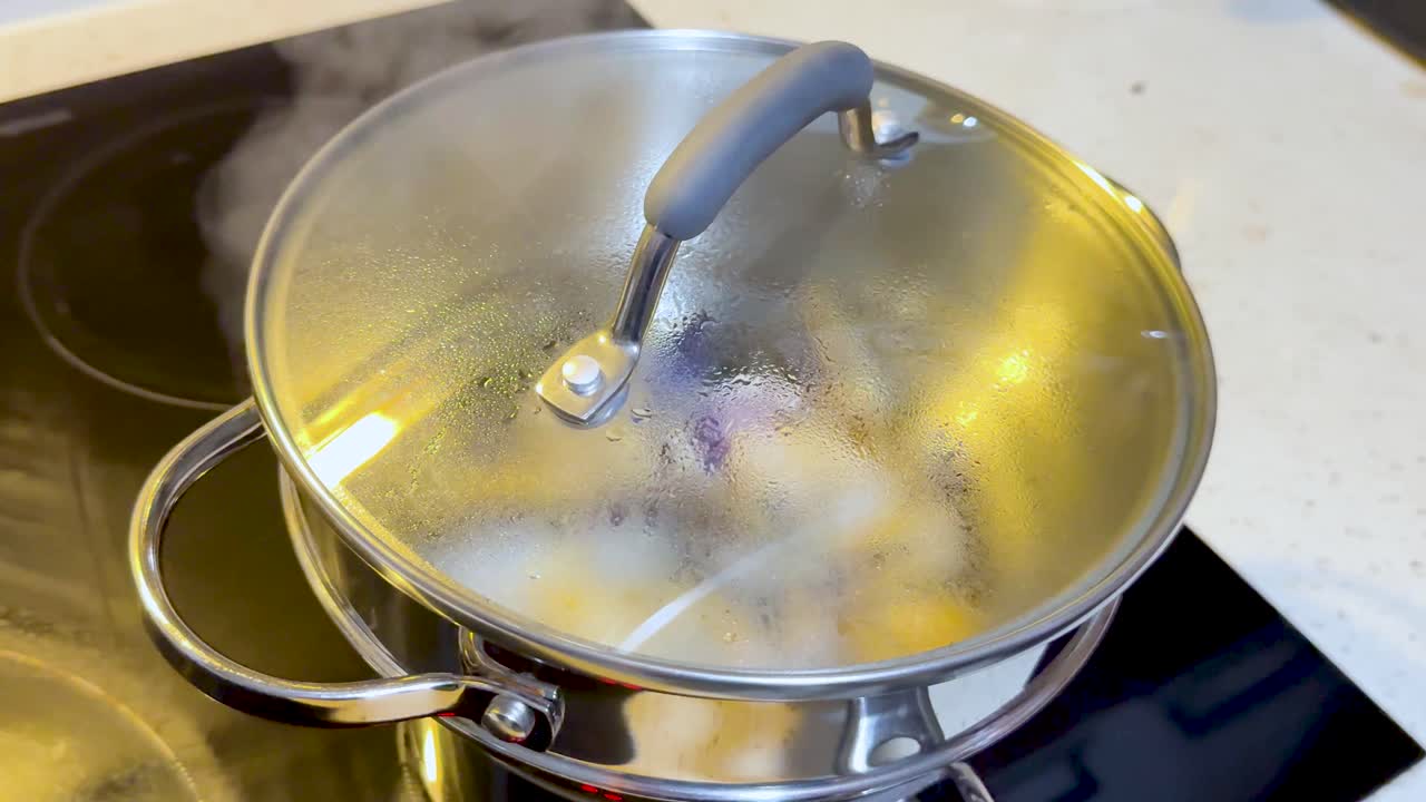 el vapor se eleva de la olla en la estufa de la cocina