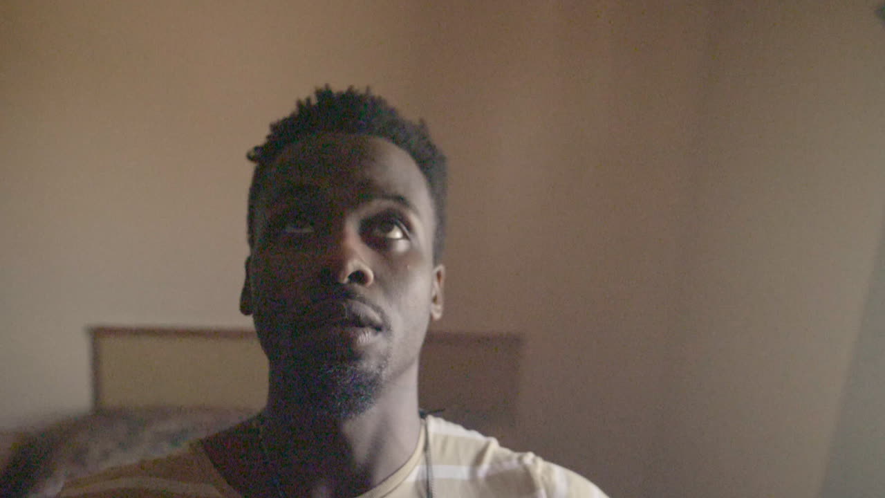 мужчина афроамериканского происхождения падает на кровать в замедленной съемке