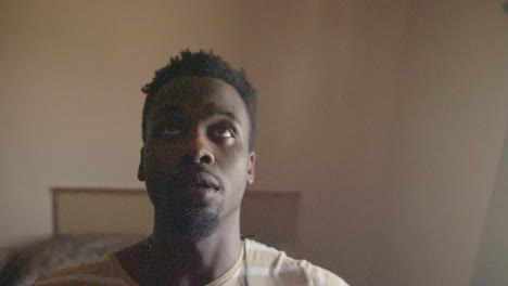 hombre afroamericano cayendo sobre la cama en cámara lenta