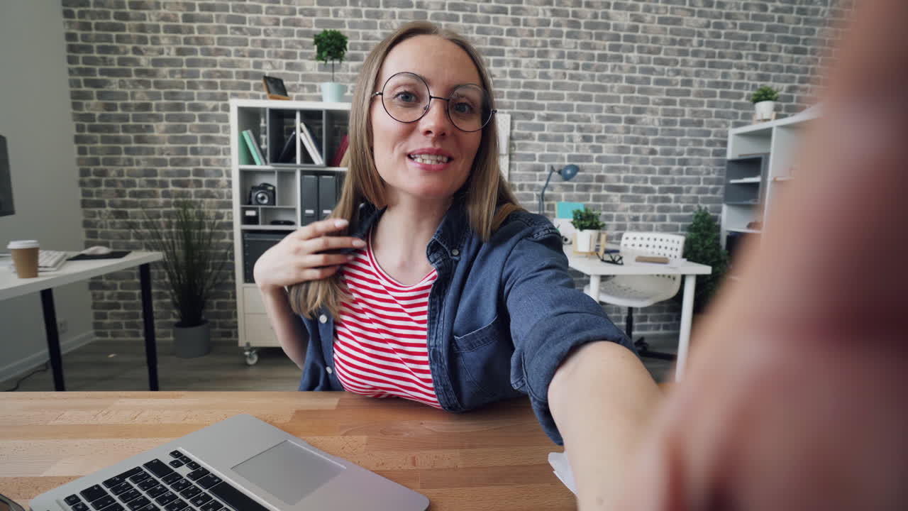 mujer tomando una selfie en la oficina