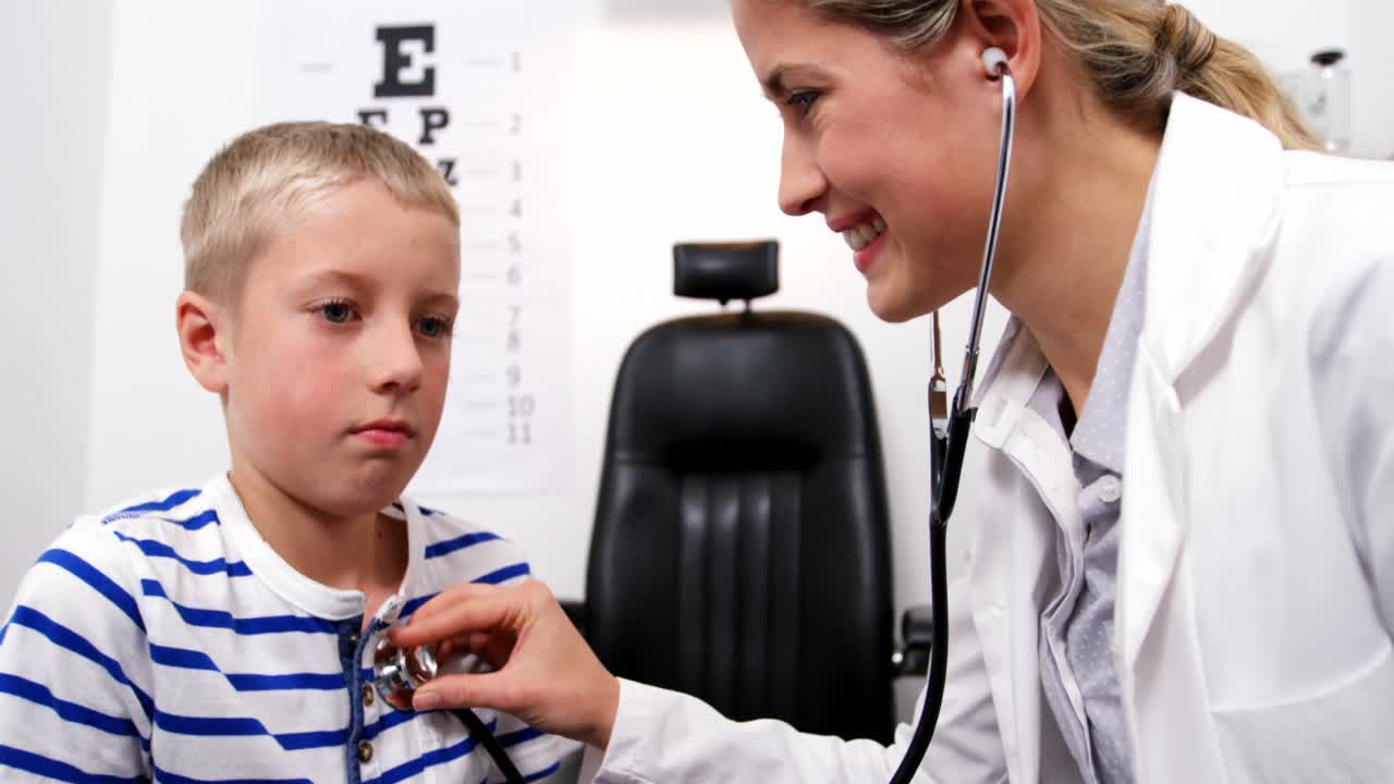 Female doctor examining young patient with a stethoscope