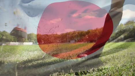 rugby player kicking the ball with a japanese flag