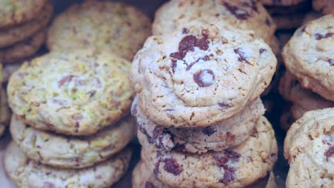 close up shot of a stack of chocolate chip cookies and pistachio cookies