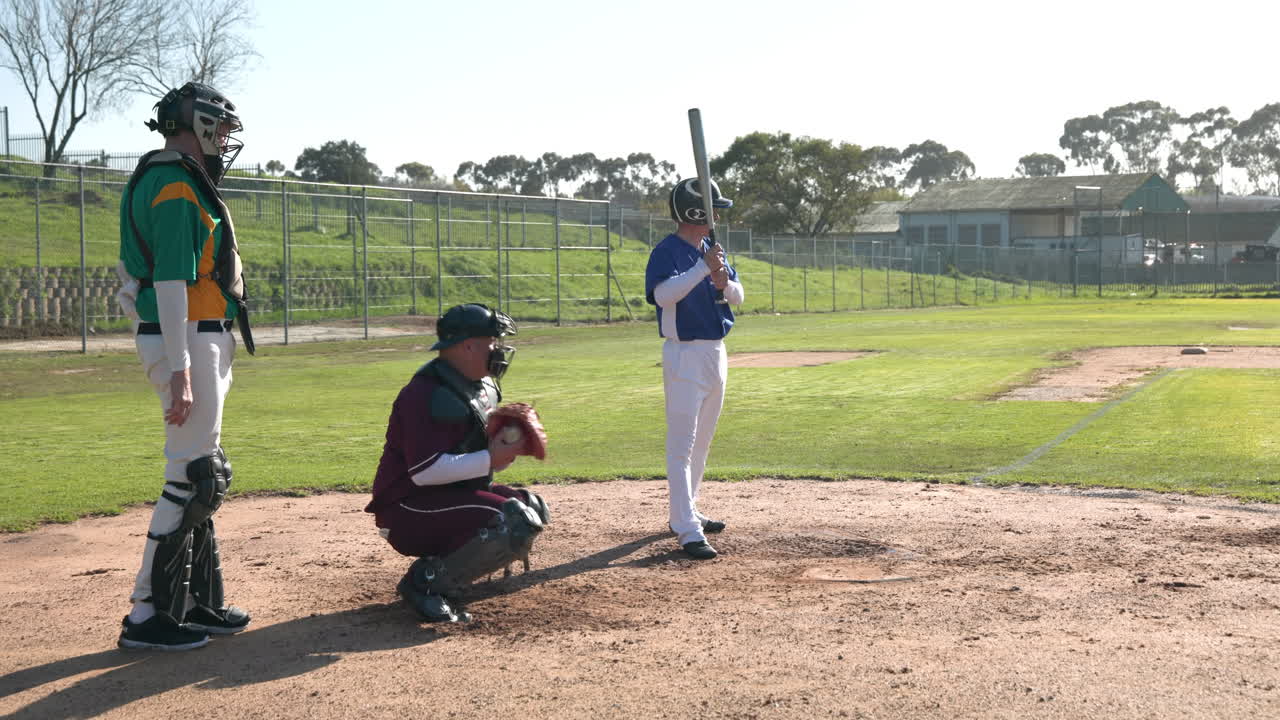 Playing baseball, batter preparing to hit while catcher and umpire ready