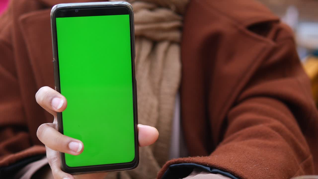 mujer con un teléfono de pantalla verde