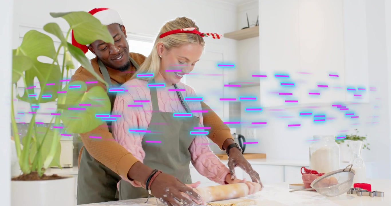 Man wrapping arms around woman in kitchen cooking guiding rolling pin rolling dough for treat