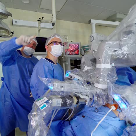 robotic surgery in clinic. medical operation involving robot. concentrated doctors in medical uniform and masks look ahead during surgery. minimally invasive robotic surgery