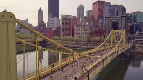 aerial fly over shot of runners crossing bridge, pittsburgh marathon