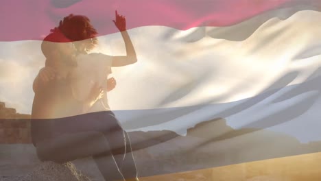 animación de la bandera de los países bajos sobre una pareja afroamericana en la playa