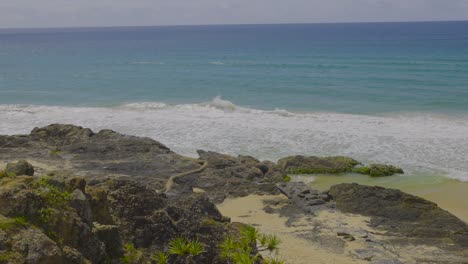 las olas golpean las rocas en la playa de currumbin, australia