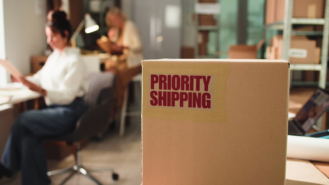 Scatola di cartone con etichetta di spedizione prioritaria in un ufficio e-commerce