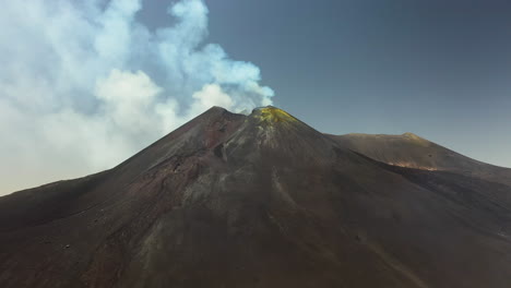 mount etna rotating aerial shot with smoke or steam coming out of the active volcano in sicily italy