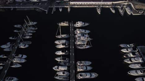 "drone footage at sunset over la duquesa port in sabinillas, málaga. a bird's-eye view advances over the marina, showcasing docked boats, the harbor, and the serene coastal charm."