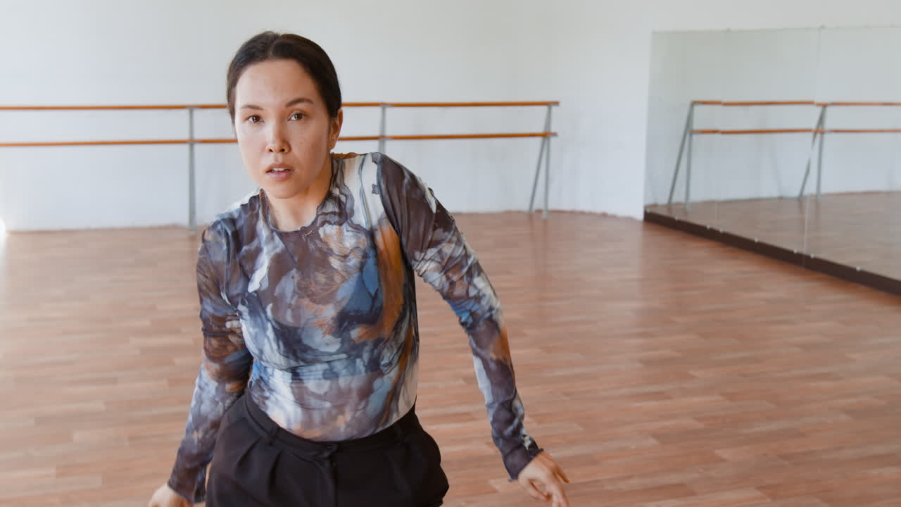 A woman dancing and posing in a bright studio