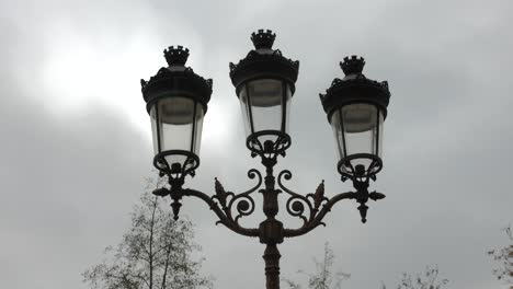 vintage french street light against moody sky in paris, france