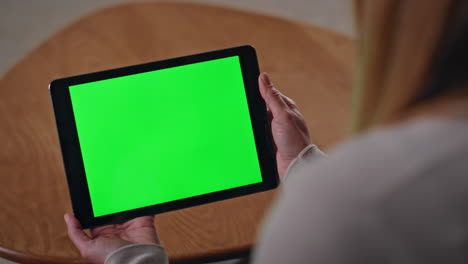 unrecognizable girl looking chroma key tablet at remote workplace close up.