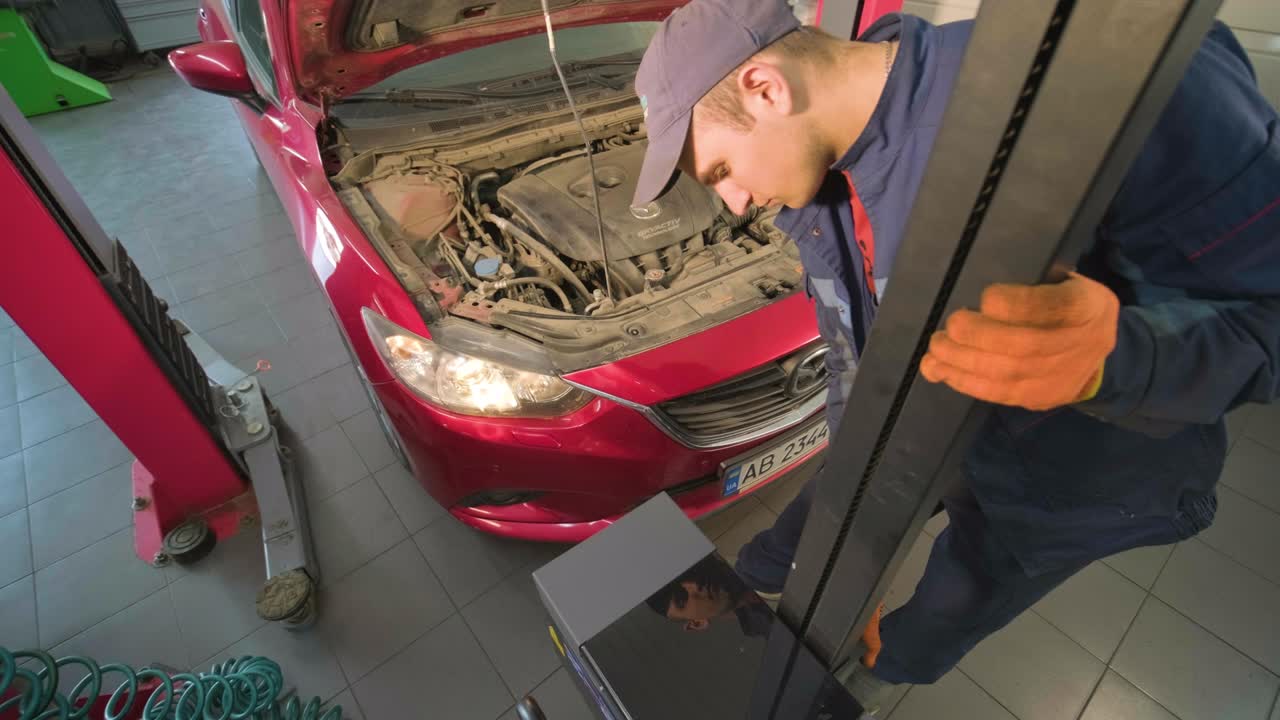 trabajador comprueba y ajusta los faros del sistema de iluminación de un automóvil. servicio de reparación de automóviles.