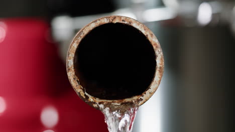 rusty water pipe with flowing water