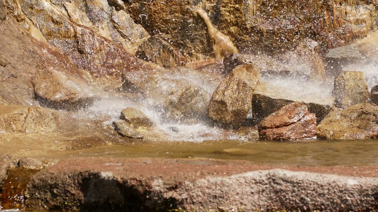 hermosa cascada desde un acantilado en el bosque. 4k video de agua que fluye, arroyo que fluye entre las piedras. arroyo en el bosque
