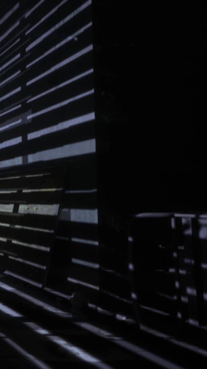 Light patterns from window blinds in a dark room at night