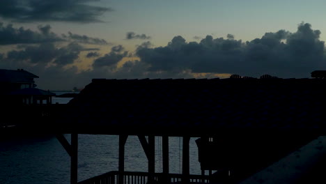 Sunset-off-the-Texas-coast-behind-silhouetted-houses-and-trees