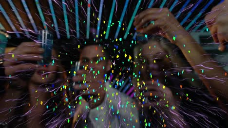 Confetti-falling-and-purple-light-trail-exploding-over-group-of-friends-doing-shots-at-a-bar