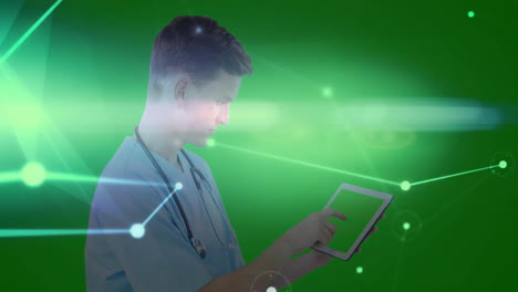 male doctor tapping tablet in green studio, overlaying holographic health interface graphics