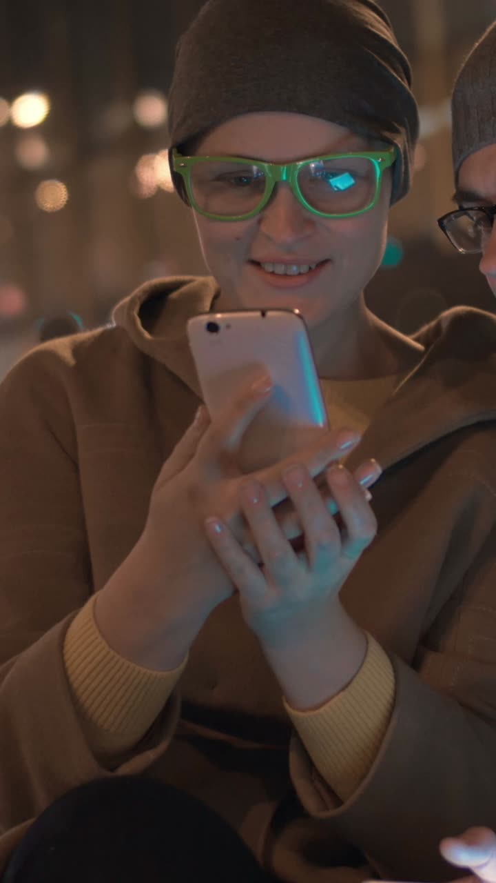 Couple using smartphones at night